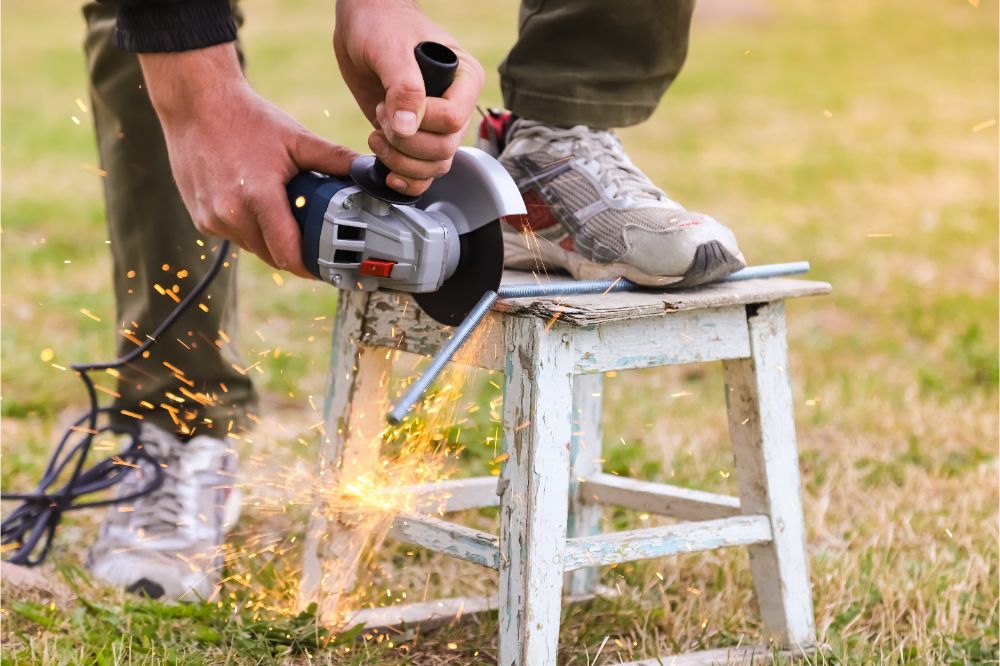 Man holds angle grinder with hands and cuts metal