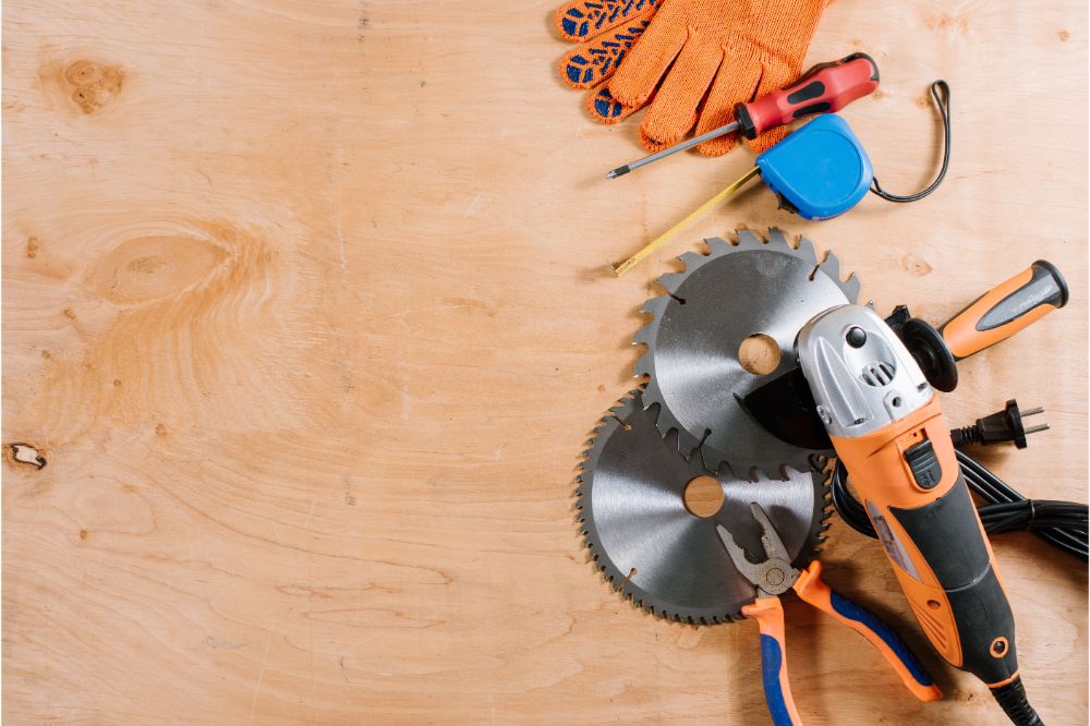 Angle grinder with accessories flatlay on wooden background